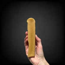 A photo of a hand holding an XL yak chew